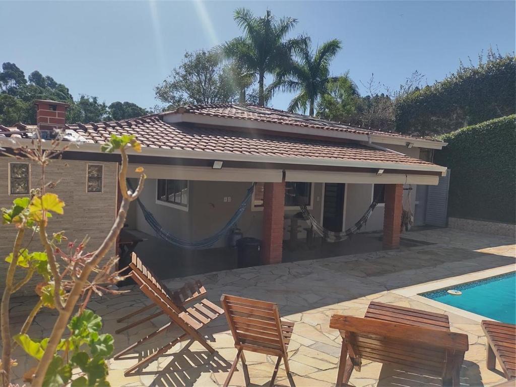 a house with chairs and a swimming pool at Um lugar para descansar e relaxar in Serra Negra