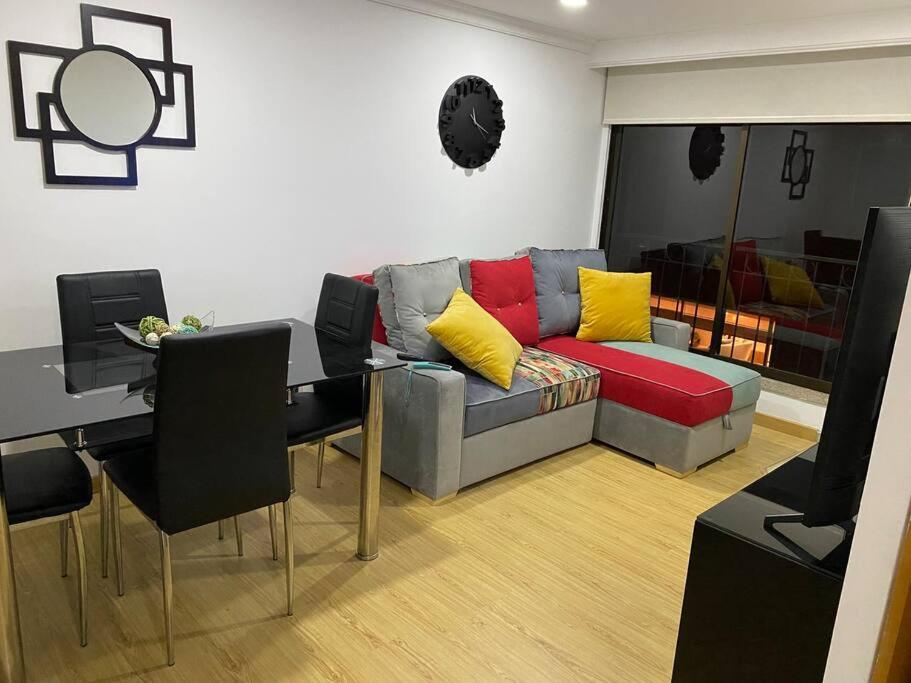 a living room with a couch and a table at Hermoso y acogedor apartamento. in Bogotá
