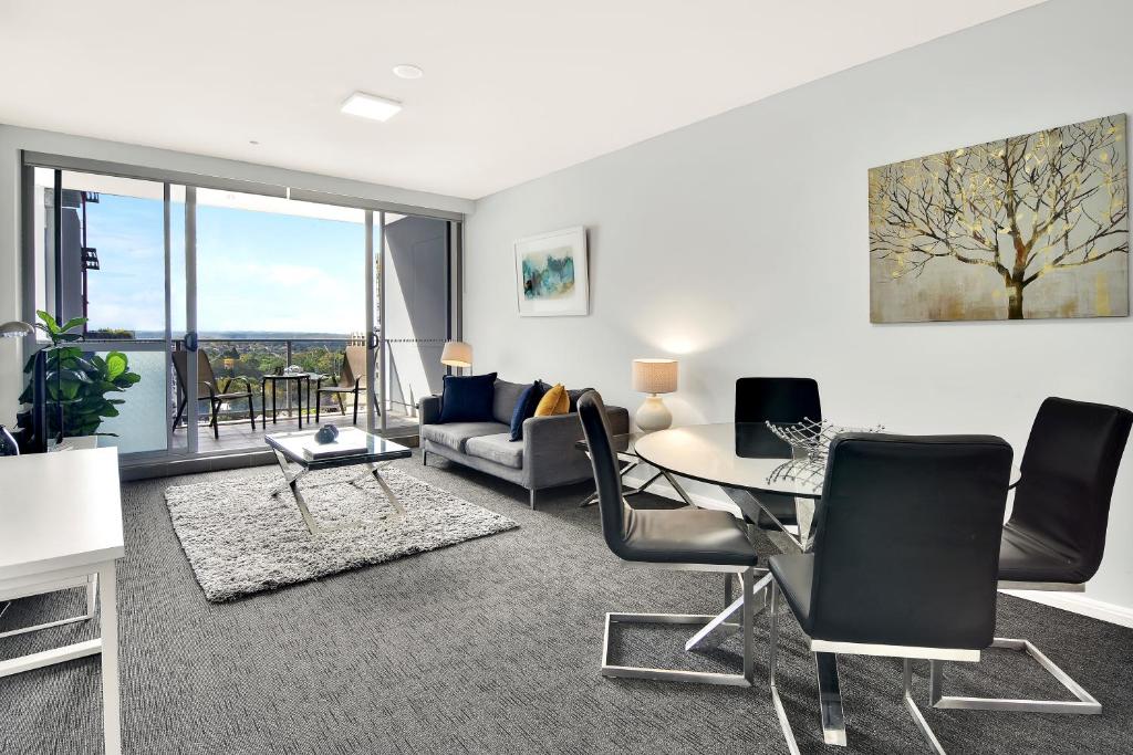 sala de estar con mesa y sillas en North Sydney Large Two Bedroom MIL2302 en Sídney