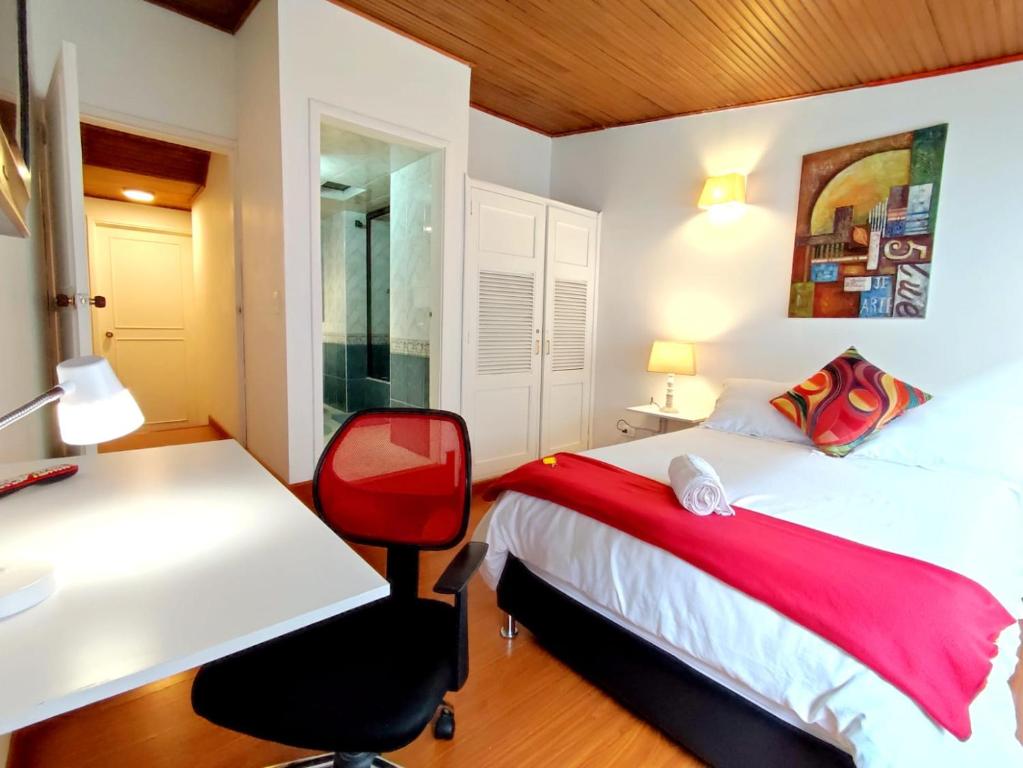 1 dormitorio con cama, escritorio y silla en HABITACION 1 independiente baño y balcón privado, en Bogotá