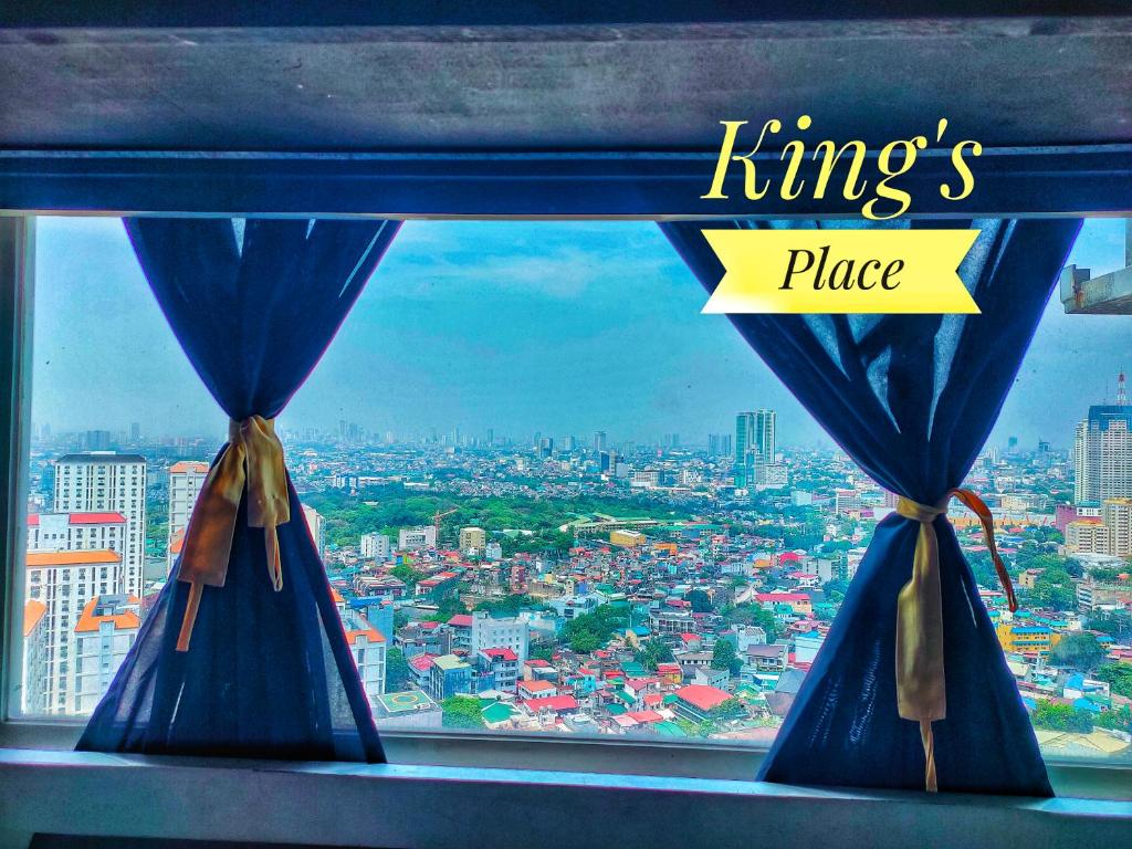 a window with blue curtains and the words kings place at Studio type Good for 2 Near Megamall in Manila