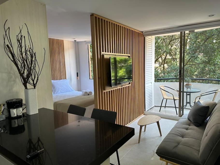 un salon avec un canapé, un lit et une table dans l'établissement Exclusivo Loft en el poblado-rodeado de naturaleza 501, à Medellín