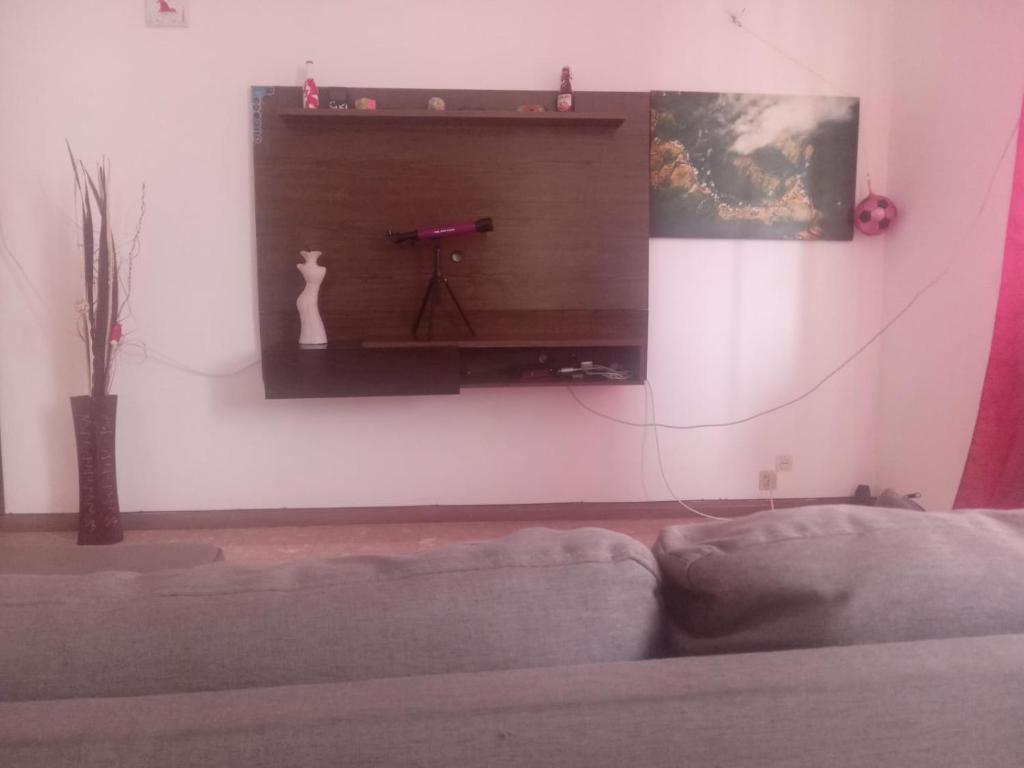 a living room with a couch and a tv on a wall at Cubico Tota in Praia