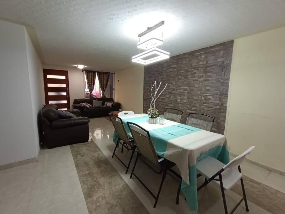 Luxos Casa Residencial Privada : غرفة طعام مع طاولة وكراسي زرقاء