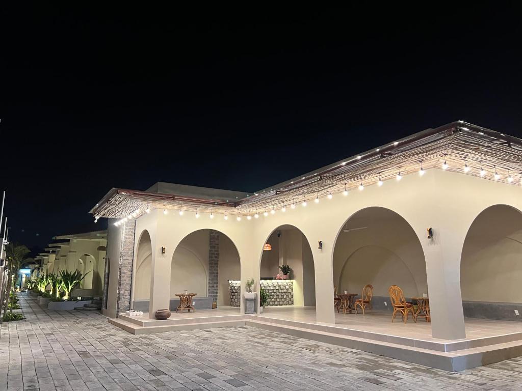 a white building with a patio at night at escVACA - Your Stay in Mui Ne in Mui Ne