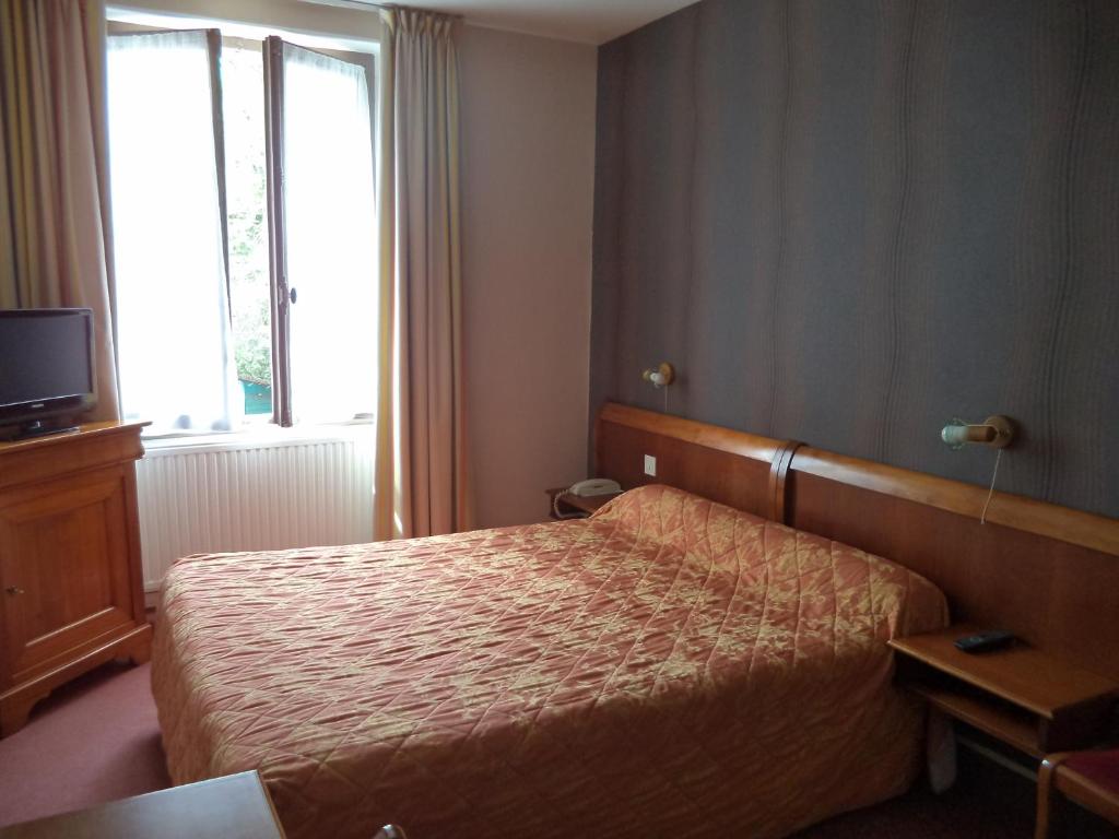 a hotel room with a bed and a window at Cit&#39;Hotel Avallon Vauban in Avallon