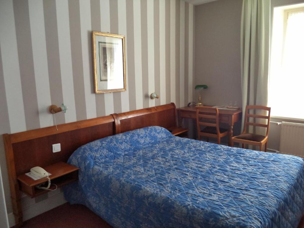 a hotel room with a bed and a table and chairs at Cit&#39;Hotel Avallon Vauban in Avallon