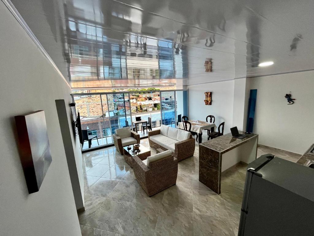 una sala de estar con sofás, mesas y una gran ventana. en APARTAMENTOS SUPER PENTHOUSE con BALCÓN, en El Colegio