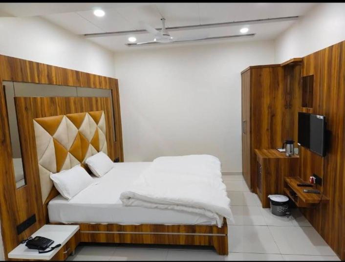 um quarto com uma cama grande e uma televisão em Reva Prabhu Sadan em Ambaji
