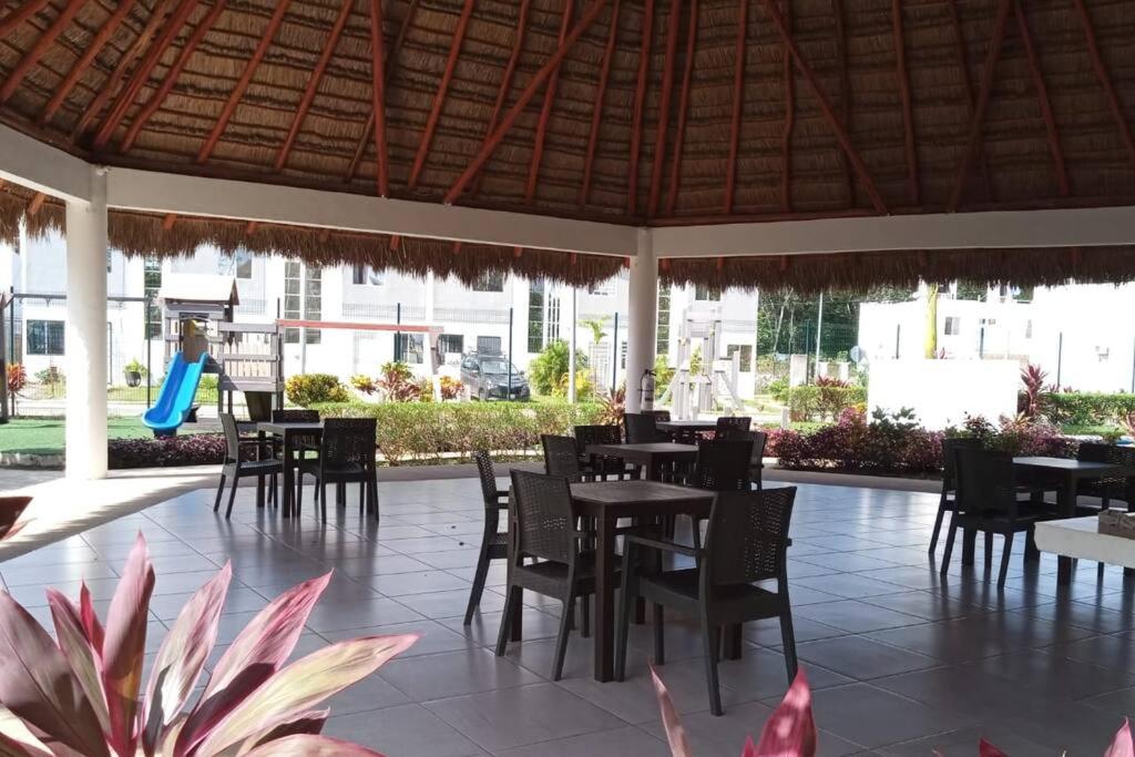 un restaurante con mesas y sillas y un patio en Hermosa casa en privada en Cancún