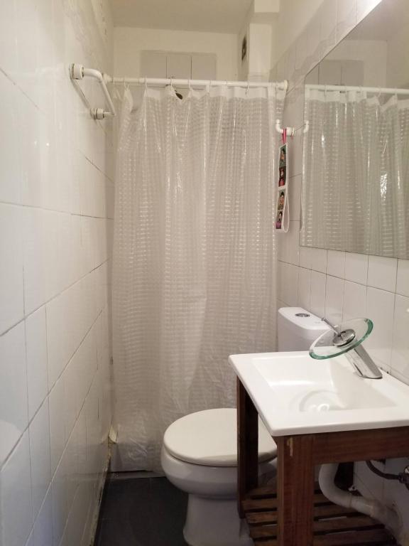 een witte badkamer met een toilet en een wastafel bij Bonpland Studio in Buenos Aires