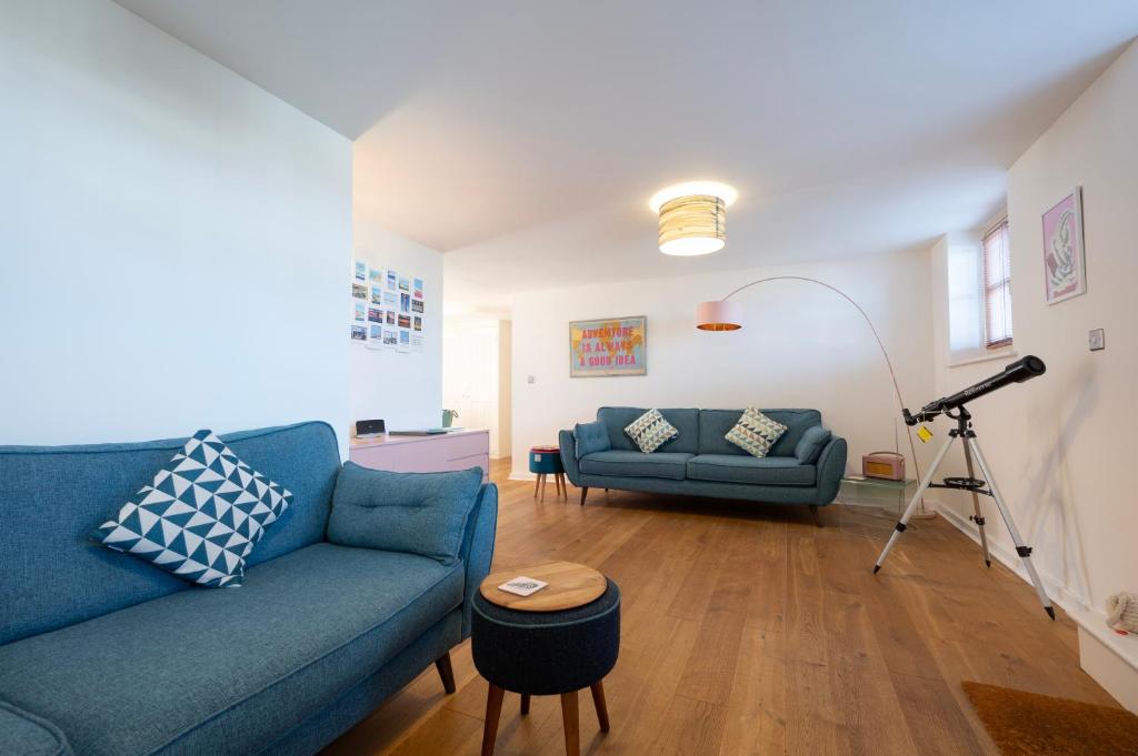 a living room with a blue couch and a table at Albert's of Margate at The Royal Seabathing in Margate