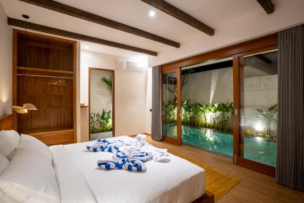 a bedroom with a bed and a swimming pool at Atania Villa's Bingin in Uluwatu