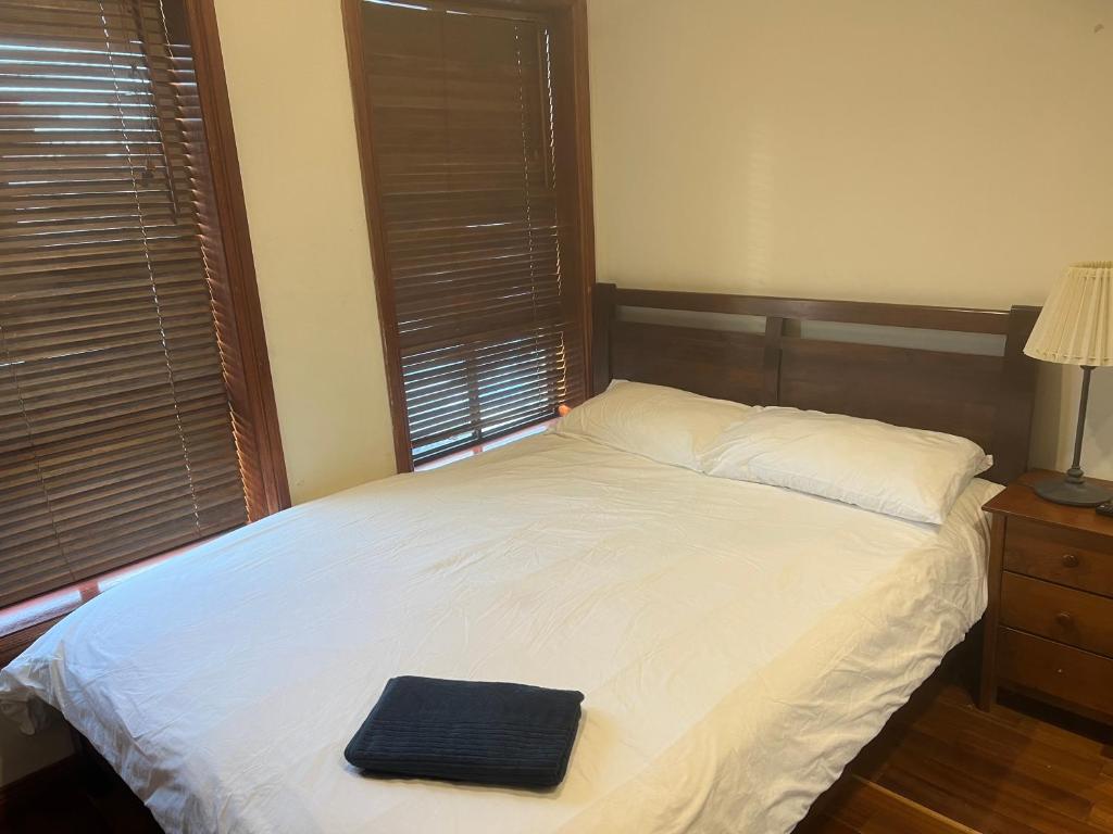a bed with a black towel on top of it at Grannyflat in Bankstown