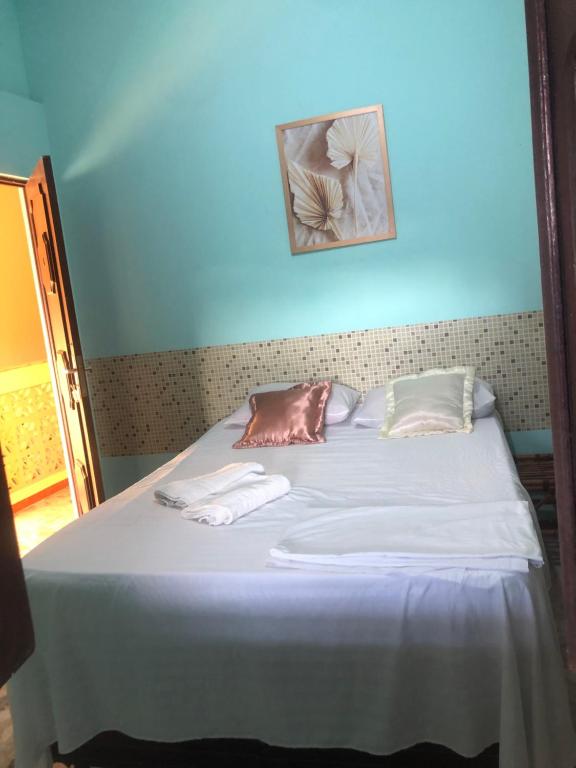 Una cama con dos almohadas encima. en Pousada Biribiri, en Salvador