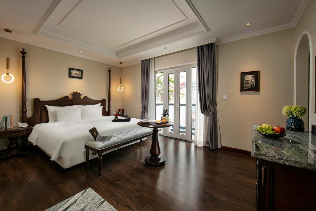 a bedroom with a bed and a table and a window at La Mejor Hotel & Sky Bar in Hanoi