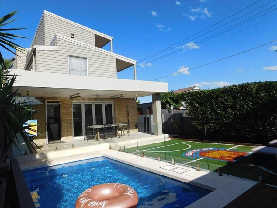 a house with a swimming pool in front of a house at Clovelly Beach House with Pool in Sydney