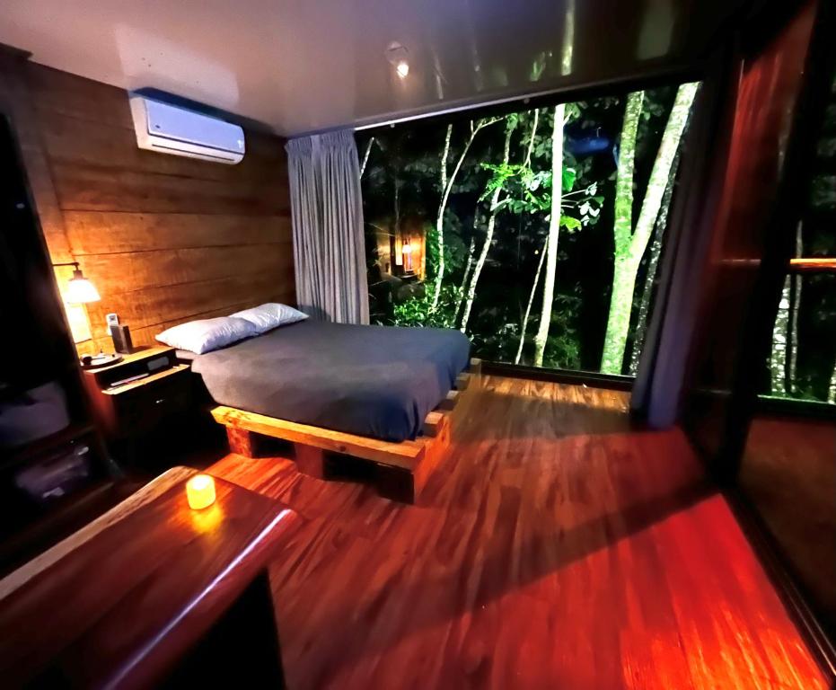 een slaapkamer met een bed en een groot raam bij Sweet Jungle in Quesada