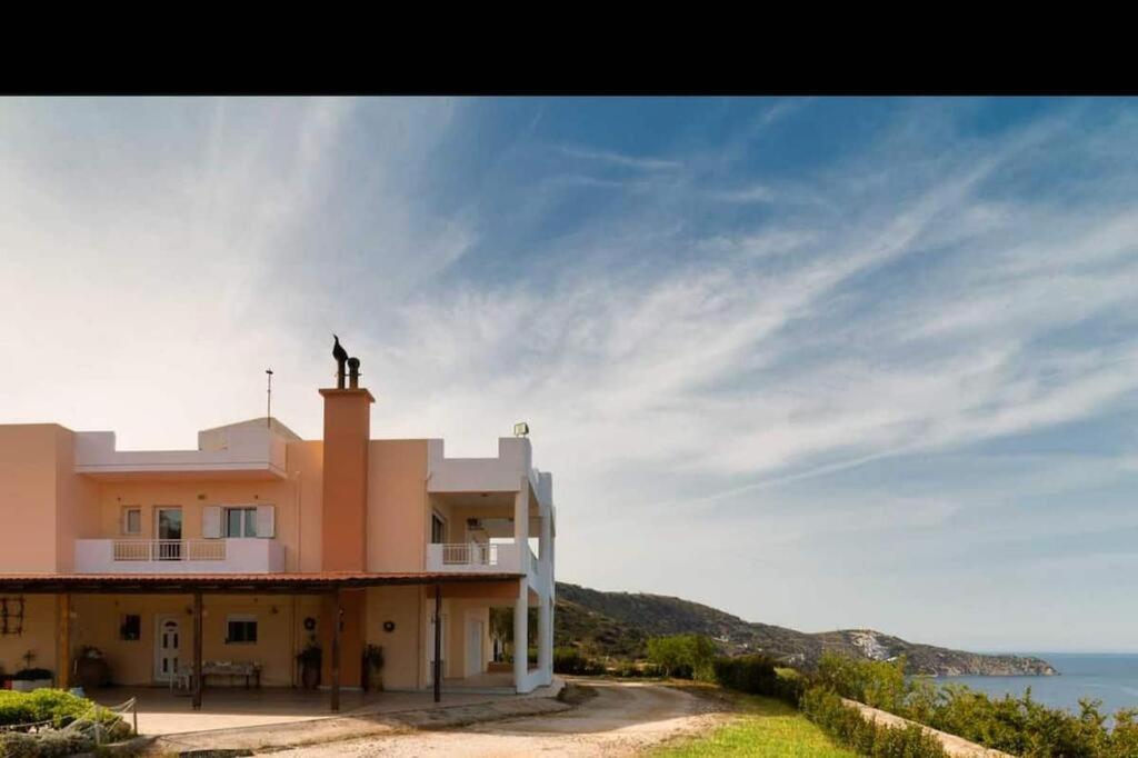 un edificio con una estatua en la parte superior junto al océano en ENASTRON HOME WITH SEA VIEW, en Palaiokastro