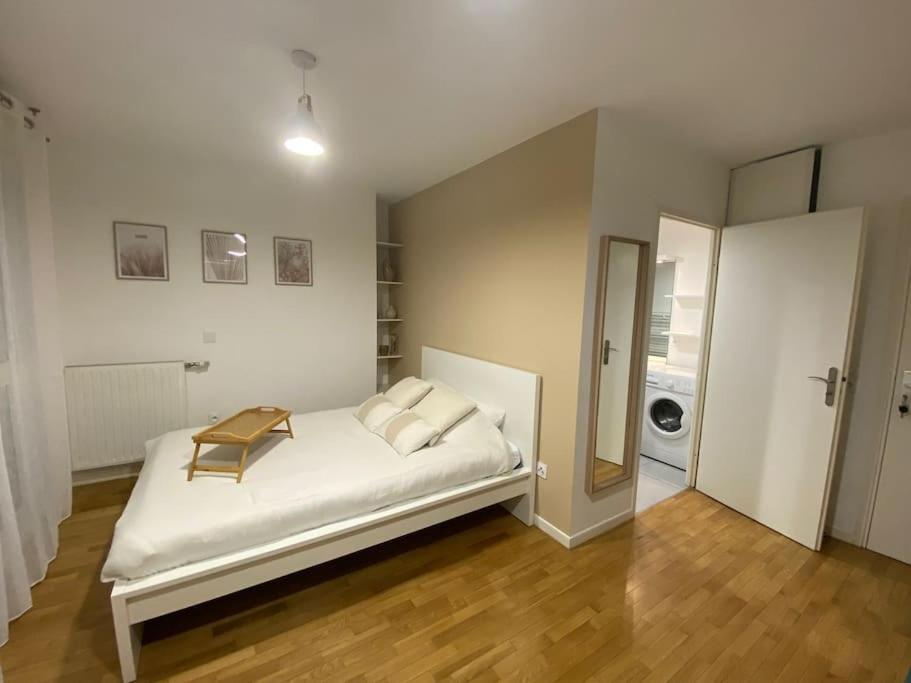 Un dormitorio con una cama con una mesa. en Studio Cosy à 10 min de Paris, en Deuil-la-Barre