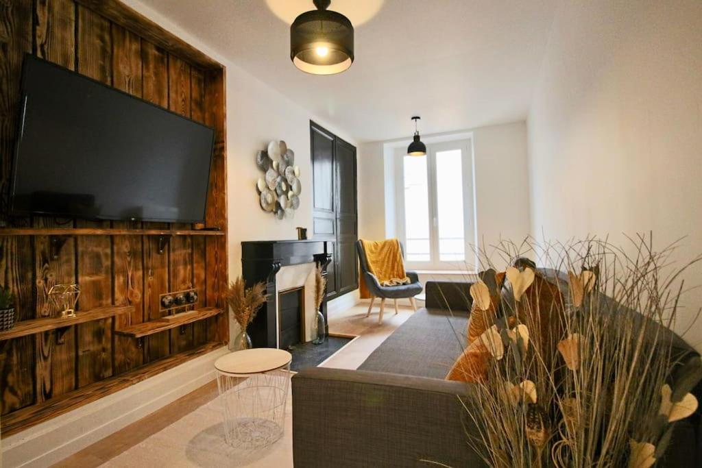 Appartement centre Brioude في بريود: غرفة معيشة مع تلفزيون بشاشة مسطحة كبيرة