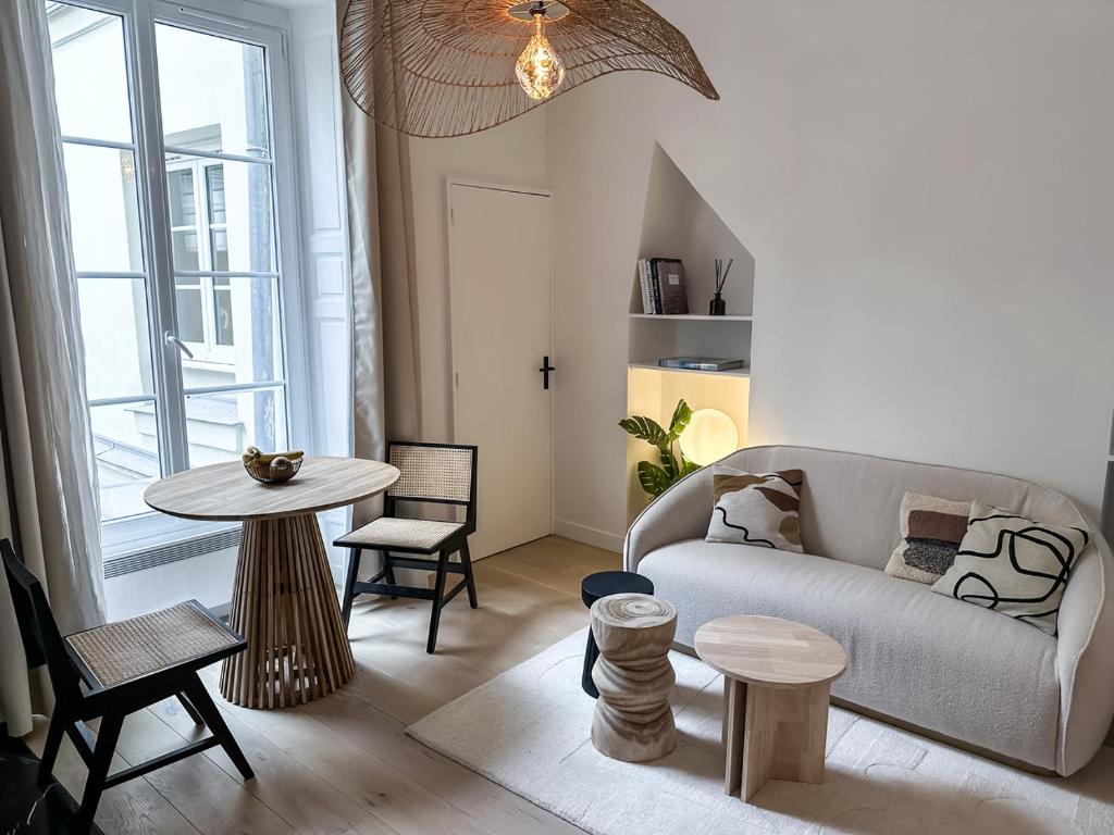 un salon avec un canapé et une table dans l'établissement Canettes Deluxe Apartment, à Paris