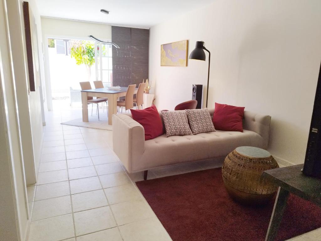 a living room with a couch and a table at Spacieux Duplex Casa Maya Caleta de Fuste in Caleta De Fuste