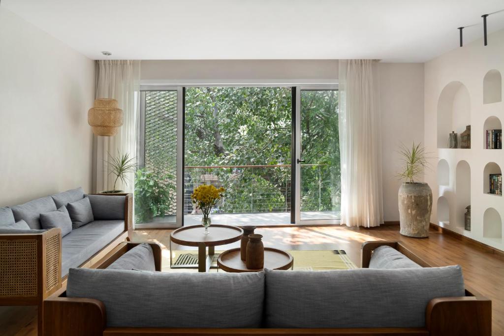 a living room with a couch and a large window at Bungalow 157 in New Delhi