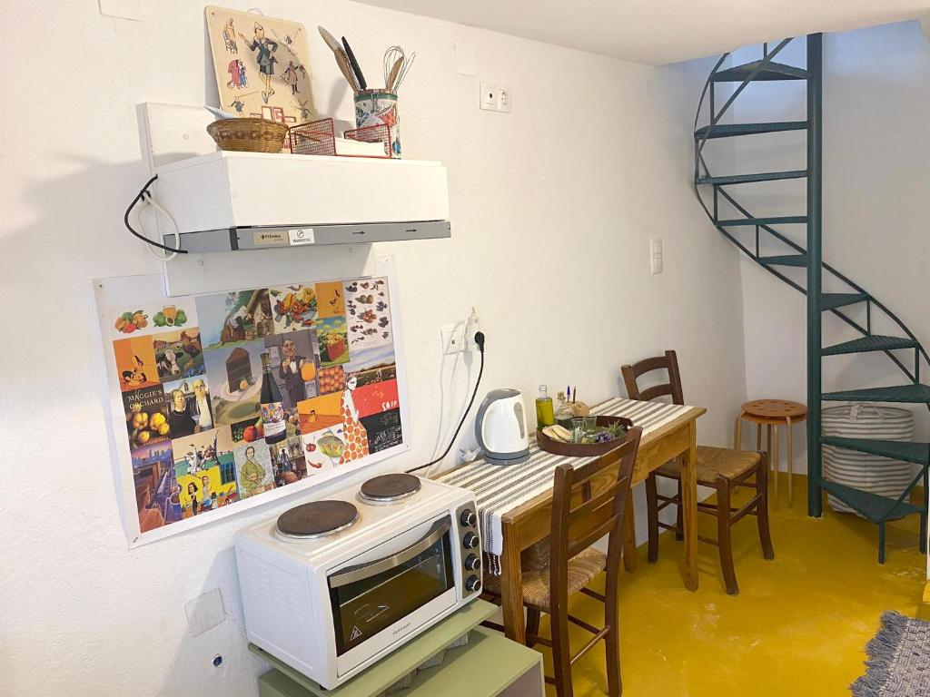 a dining room with a microwave and a table with chairs at tiny house EFROSSINI in Krásion