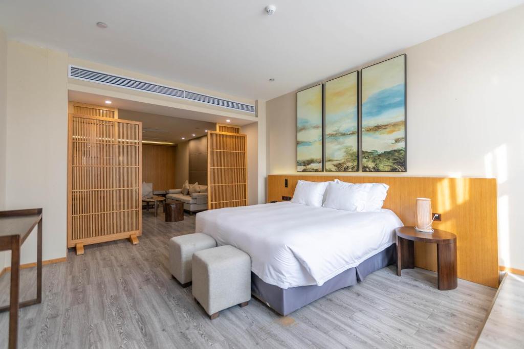 a bedroom with a large white bed and a desk at Xixi Nanlu Ssaw Boutique Hotel in Hangzhou