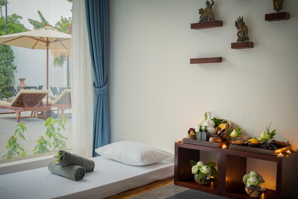 a room with a bed and a window with a patio at Sala Siem Reap Hotel in Siem Reap