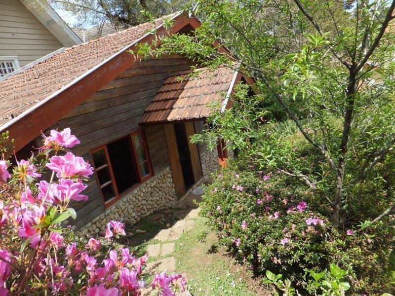 a small house with flowers in front of it at Sonja's Almhutte in Campos do Jordão