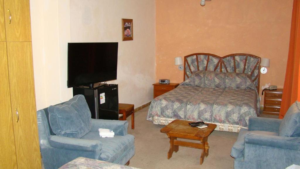 a hotel room with a bed and two chairs at Hotel Durazno in Durazno