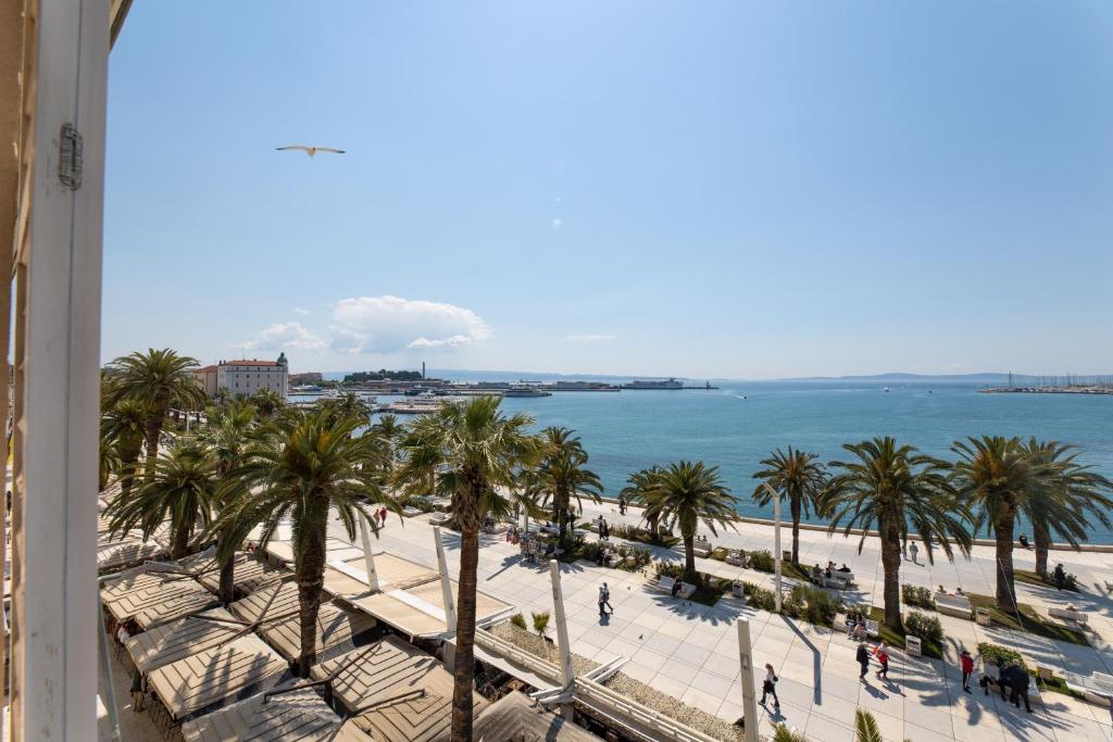 a view of a beach with palm trees and the ocean at B&B Skyfall in Split