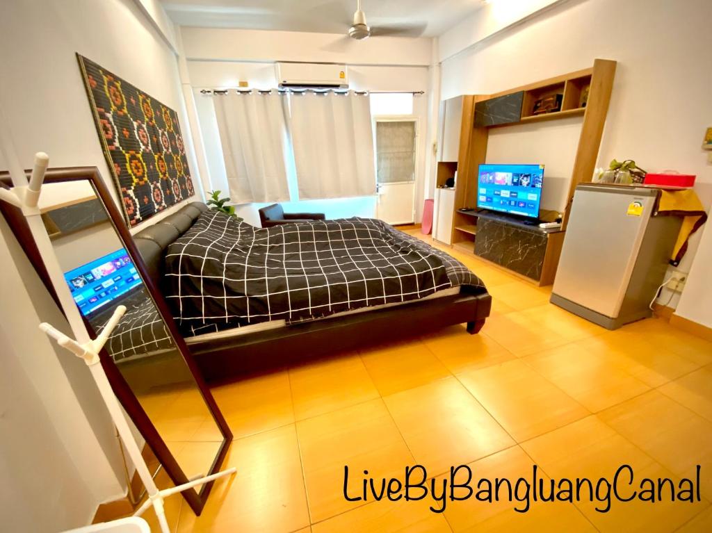 a living room with a bed and a television at BangkokFloatingMarket KhlongBangLuangStay in Bangkok Yai