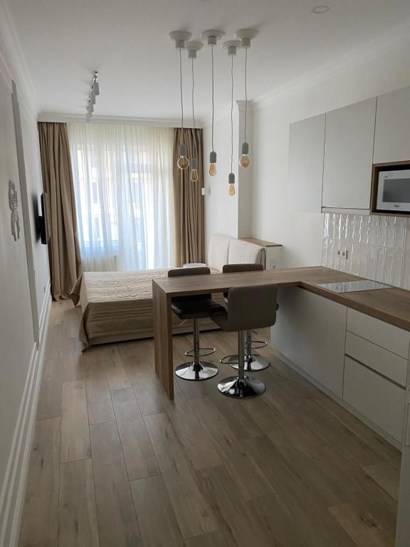 a kitchen with a table and a room with a bed at Апартаменти Корфу біля моря in Odesa