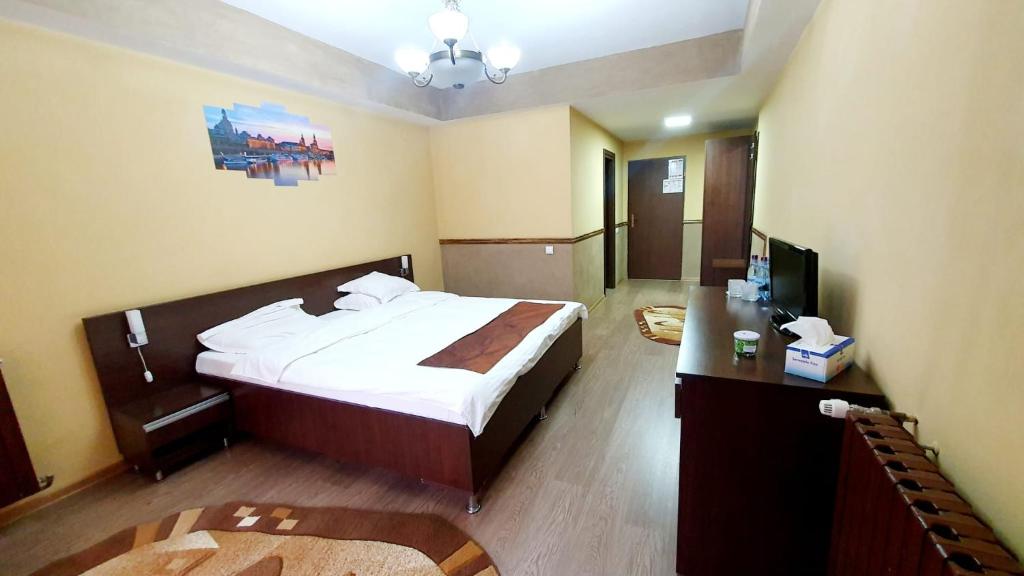 a hotel room with a bed and a television at Guest House Bulevard in Drobeta-Turnu Severin