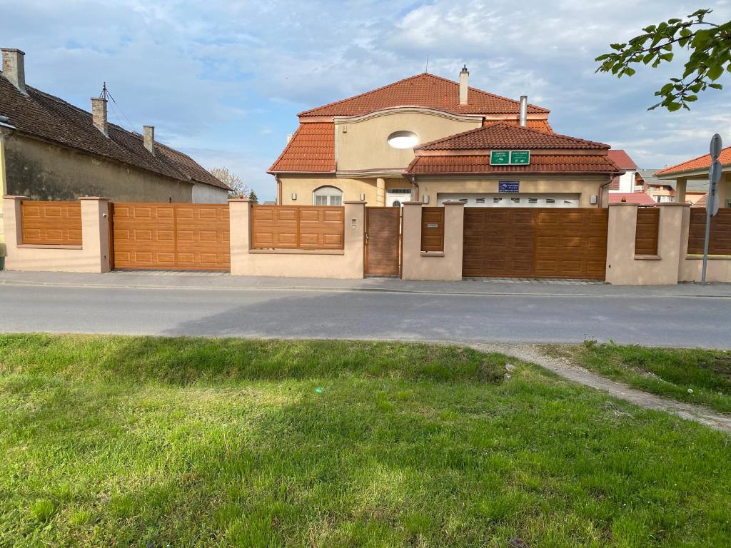 uma casa com uma cerca e uma garagem em Ambrózia Guesthouse em Nagykanizsa