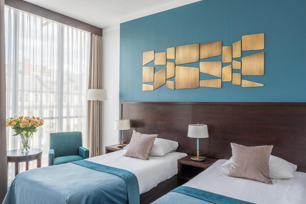 um quarto de hotel com duas camas e uma parede azul em Europeum Hotel em Breslávia