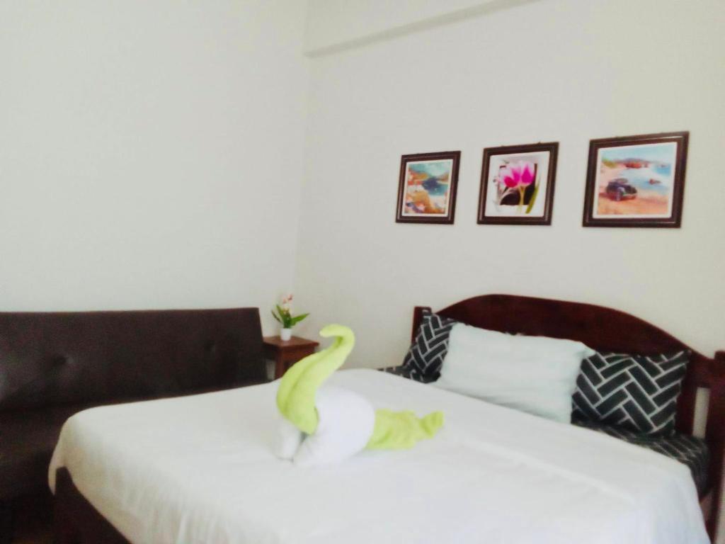 a room with two beds with a toy dinosaur on the bed at Amani Grand Residence near Mactan Cebu Intl Airport in Mactan
