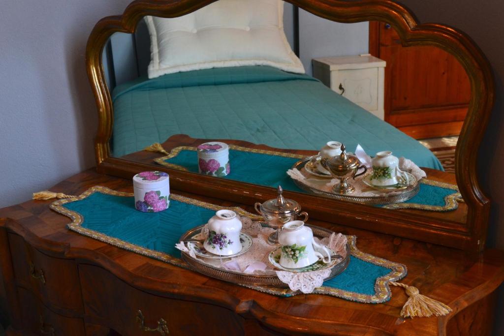 a bed with a table with tea sets on it at Cosetta Guest House in Certaldo