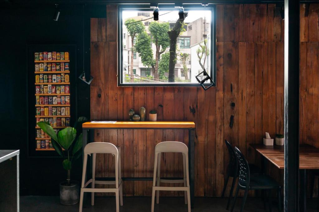 a bar with two white stools and a window at Xiang Zhai Jiao C in Jiaoxi