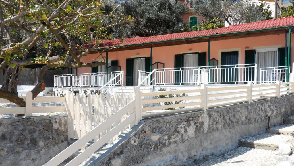 a white fence in front of a building at Kalypso Studio in Paleokastritsa