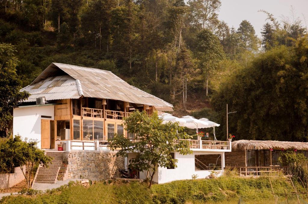 a house with a roof in a forest at Le Chalet Homestay in Bắc Hà