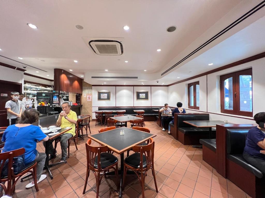 um restaurante com pessoas sentadas em mesas numa sala em Park View Hotel em Singapura