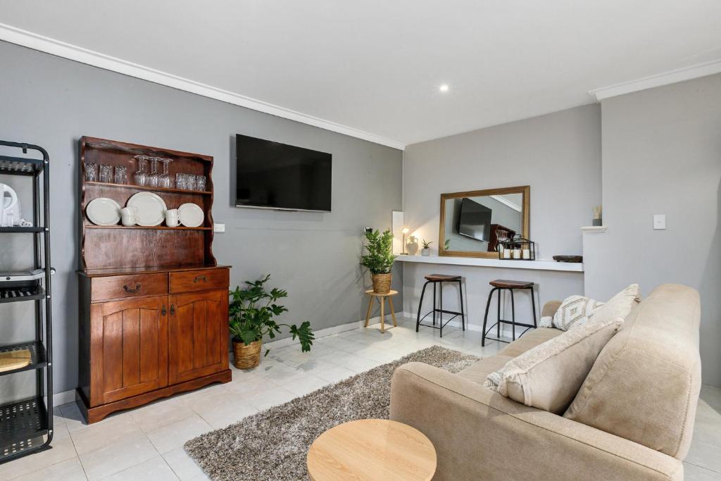 a living room with a couch and a tv at Quiet & Comfy in Hamilton Hill