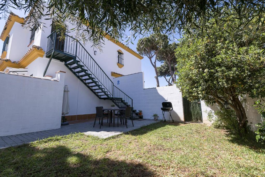 a white house with a staircase and a table and chairs at Luna de La Barrosa in Chiclana de la Frontera