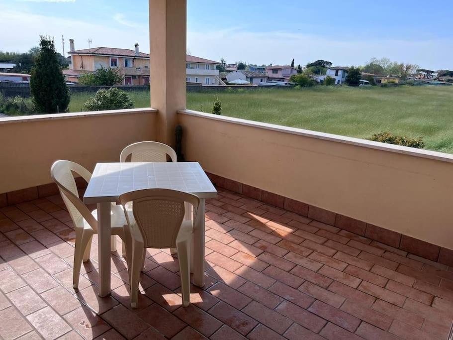 d'une table blanche et de deux chaises sur un balcon. dans l'établissement Titina's house - Peace and nature in Fiumicino, à Fiumicino