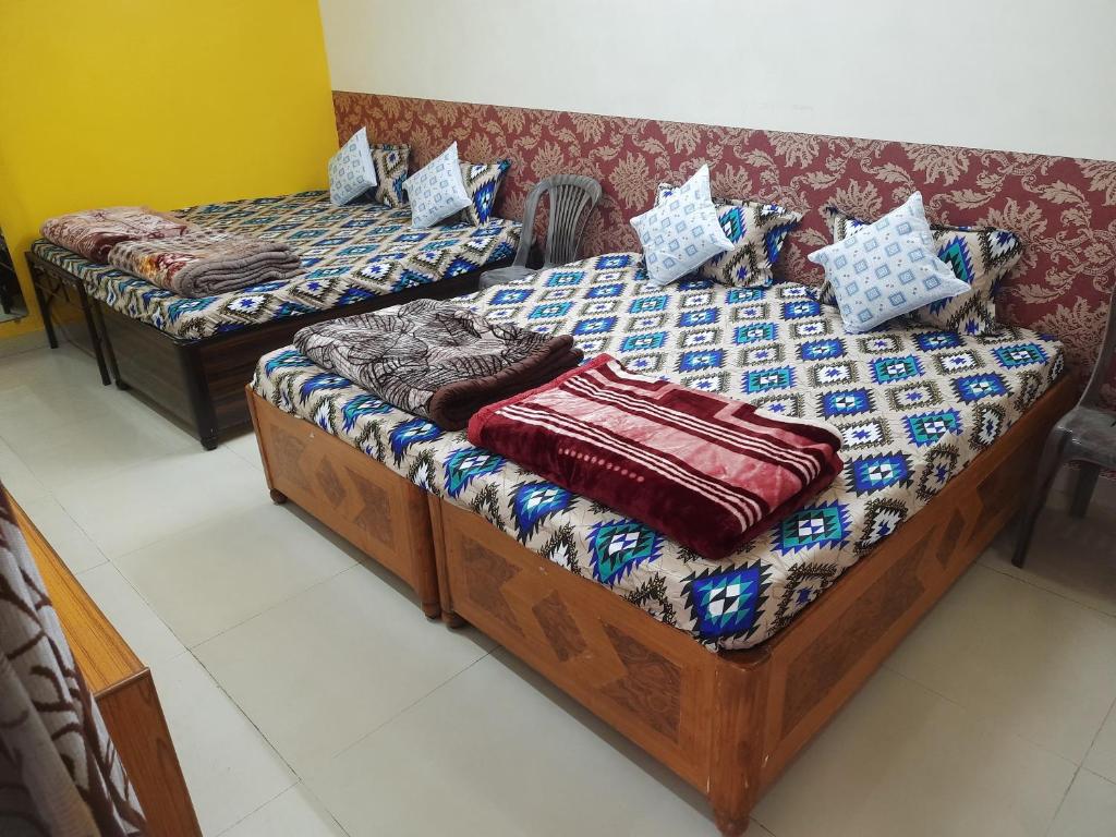 2 aparte bedden in een kamer met een bank bij Saar Homestay in Ujjain