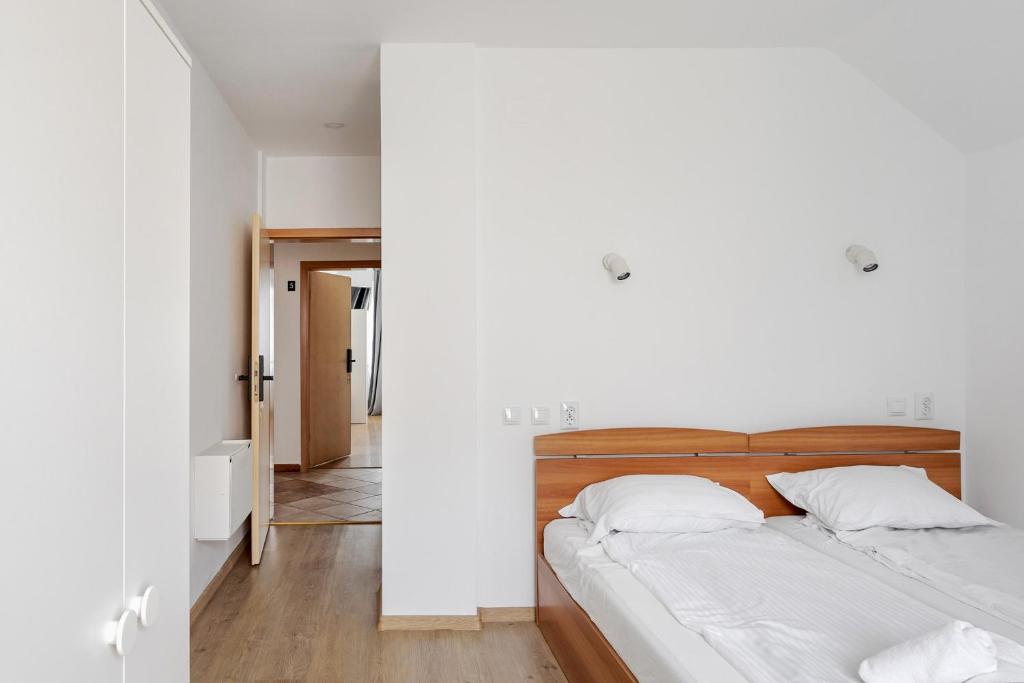 ein weißes Schlafzimmer mit einem Bett und einem Flur in der Unterkunft DD Boutique Apartments in Cluj-Napoca